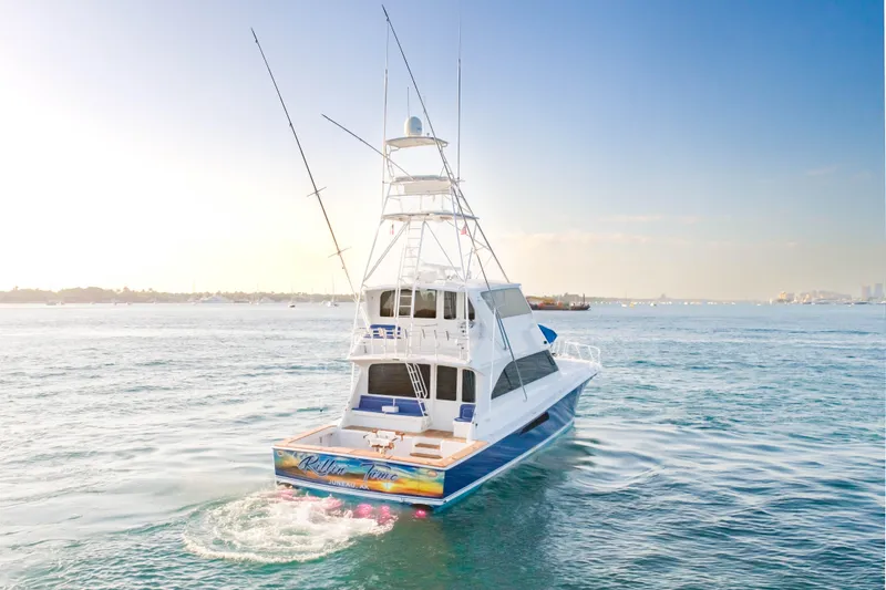 Slide: The Image of 2003 Viking 65 EB yacht cruising on calm waters under a clear sky. - 4