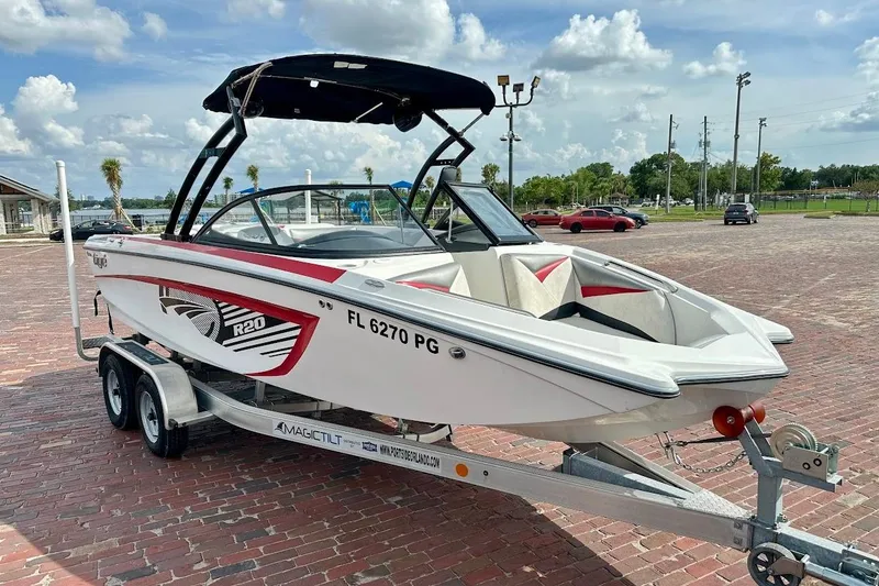 The Image of 2012 Tigé R20 boat on trailer, parked on brick pavement under a partly cloudy sky. - 1