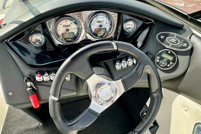 Slide: The Image of 2012 Tigé R20 boat dashboard with steering wheel and gauges. - 23