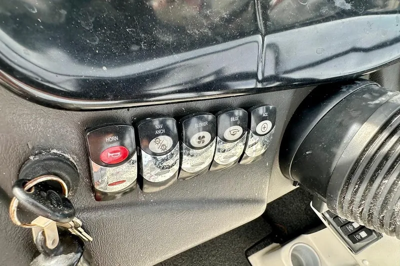 Slide: The Image of Dashboard controls of a 2012 Tigé R20 boat, featuring various switches and ignition keys. - 26
