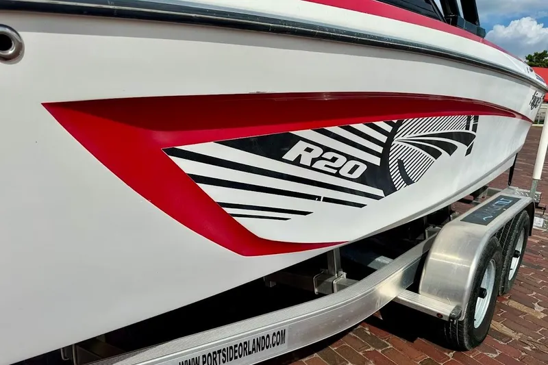 Slide: The Image of 2012 Tigé R20 boat with red and black graphics on a trailer. - 4