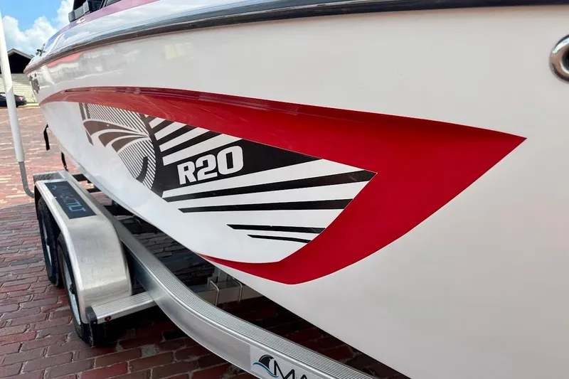 Slide: The Image of 2012 Tigé R20 boat with bold red and black graphics on a trailer. - 9