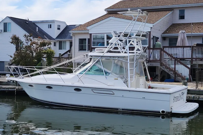 The Image of 2000 Tiara Yachts 3100 Open docked near waterfront homes. - 0