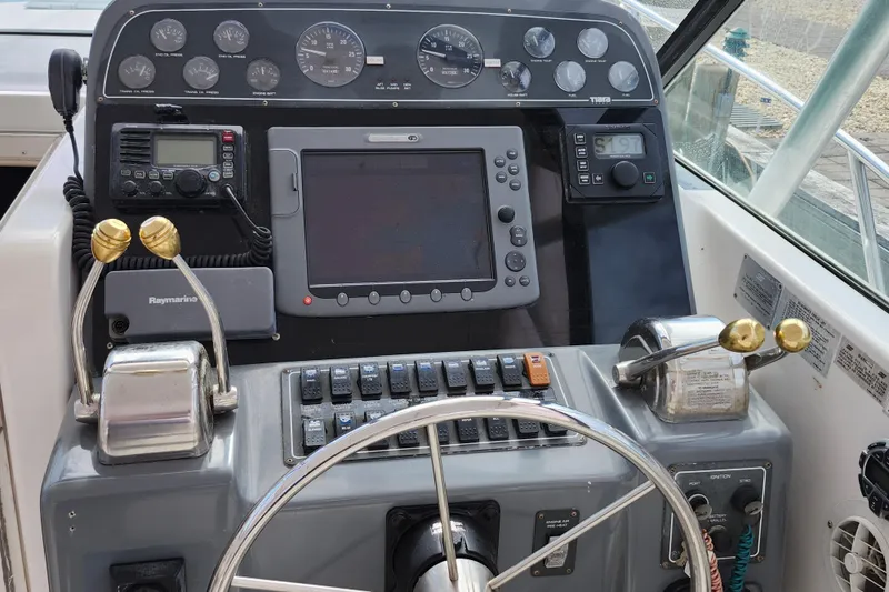 Slide: The Image of Control panel of a 2000 Tiara Yachts 3100 Open, featuring navigation and communication equipment. - 12
