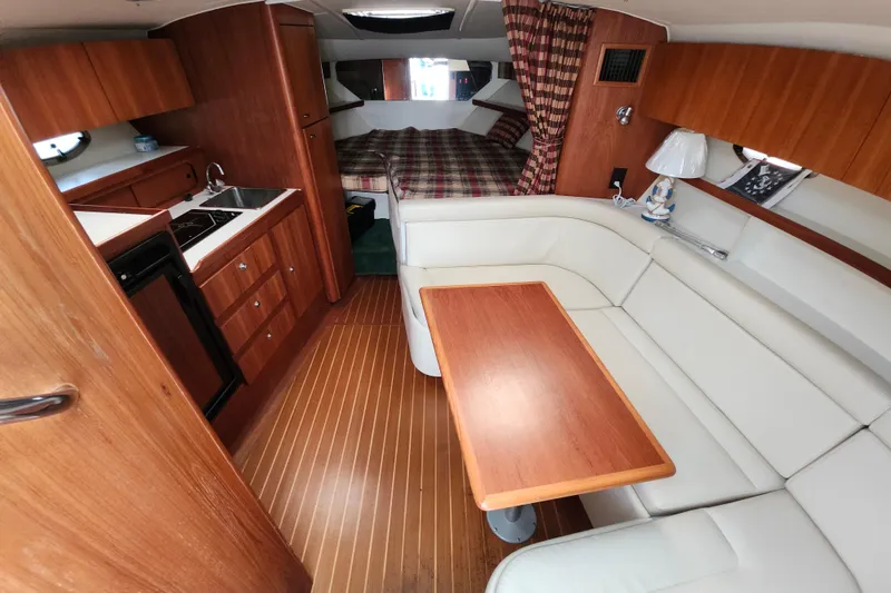 Slide: The Image of Interior of 2000 Tiara Yachts 3100 Open, featuring kitchen, seating, and sleeping area. - 14
