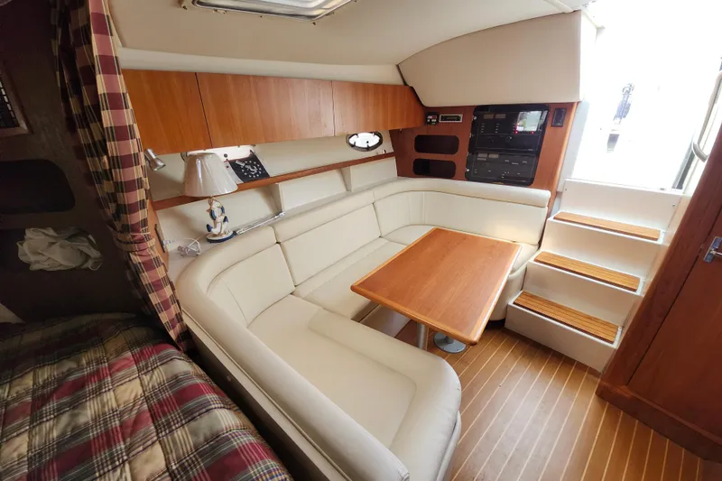 Slide: The Image of Interior of 2000 Tiara Yachts 3100 Open with cozy seating and wooden accents. - 16