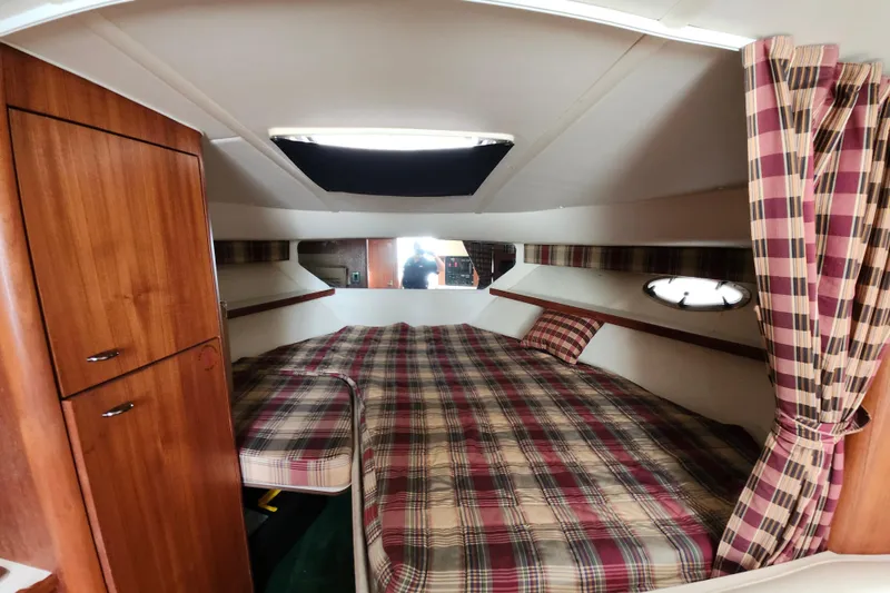 Slide: The Image of 2000 Tiara Yachts 3100 Open cabin interior with plaid bedding and wooden cabinetry. - 17