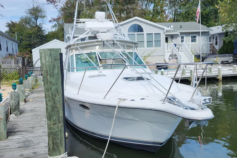 Slide: The Image of 2000 Tiara Yachts 3100 Open docked near waterfront homes. - 2