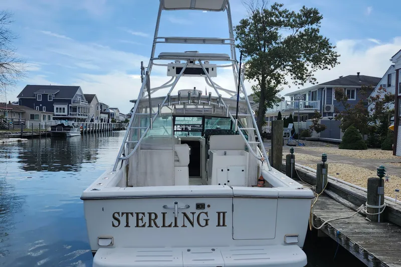 Slide: The Image of 2000 Tiara Yachts 3100 Open docked in a residential canal setting. - 3