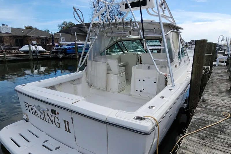 Slide: The Image of 2000 Tiara Yachts 3100 Open docked, showcasing spacious deck and sleek design. - 4