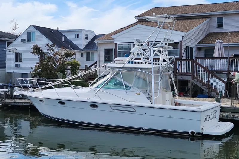 Slide: The Image of 2000 Tiara Yachts 3100 Open docked near waterfront homes. - 8