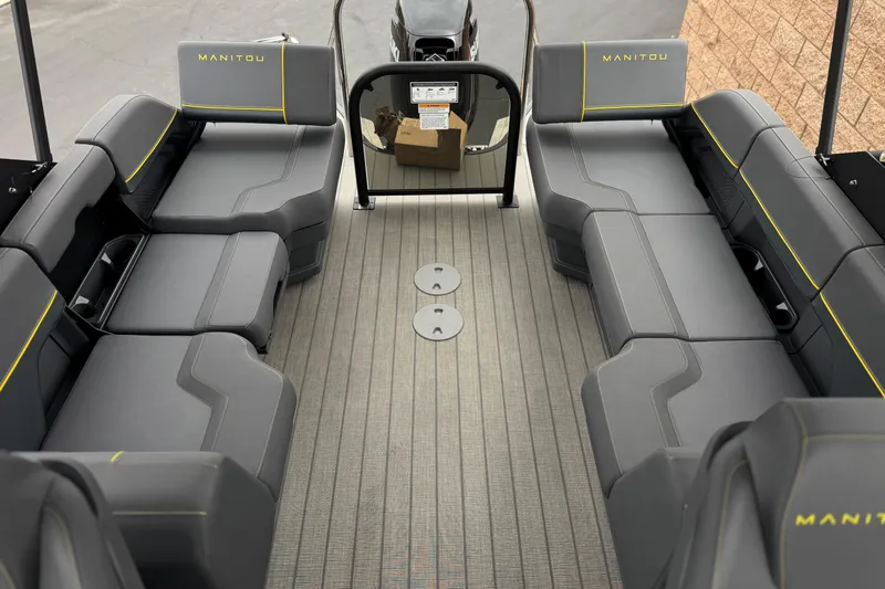Slide: The Image of 2025 Manitou EXPLORE 24 boat interior with gray seating and yellow accents. - 14