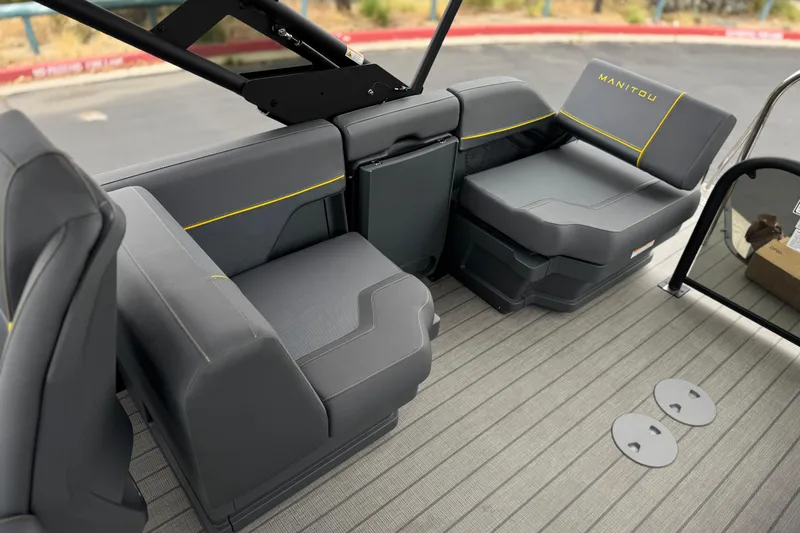 Slide: The Image of 2025 Manitou EXPLORE 24 boat interior with gray seating and yellow accents. - 16