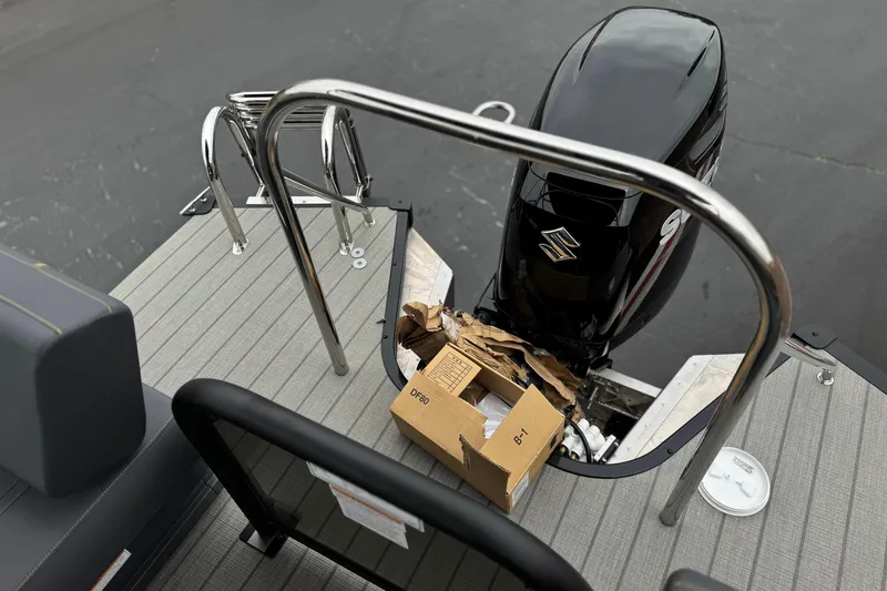Slide: The Image of 2025 Manitou EXPLORE 24 boat with Suzuki outboard motor and cardboard box on deck. - 18