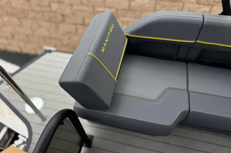 Slide: The Image of 2025 Manitou EXPLORE 24 boat seating with gray upholstery and yellow accents. - 19