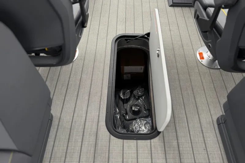 Slide: The Image of Open storage compartment on 2025 Manitou EXPLORE 24 boat, showcasing interior space and seating arrangement. - 24