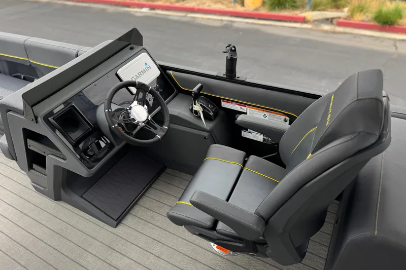 Slide: The Image of 2025 Manitou EXPLORE 24 boat cockpit with Garmin navigation and sleek black seating. - 25