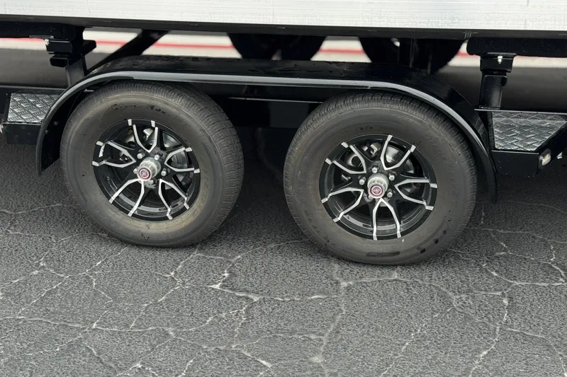 Slide: The Image of 2025 Manitou EXPLORE 24 trailer wheels on asphalt surface. - 27
