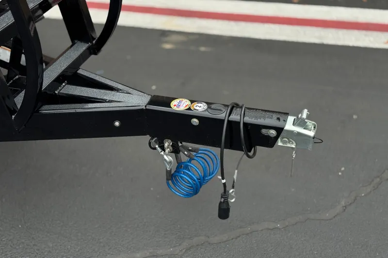 Slide: The Image of Trailer hitch of 2025 Manitou EXPLORE 24 with coiled blue cable on asphalt. - 28