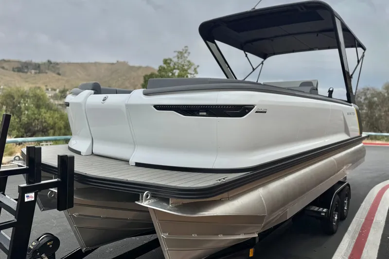 Slide: The Image of 2025 Manitou EXPLORE 24 pontoon boat on trailer, featuring sleek design and canopy. - 3