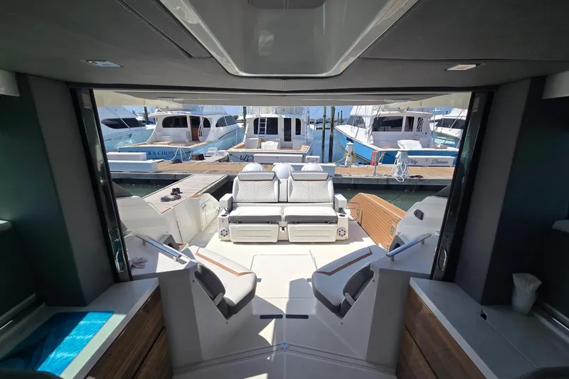 Slide: The Image of Interior view of 2022 Tiara Yachts 43 LE, showcasing luxurious seating and marina backdrop. - 11