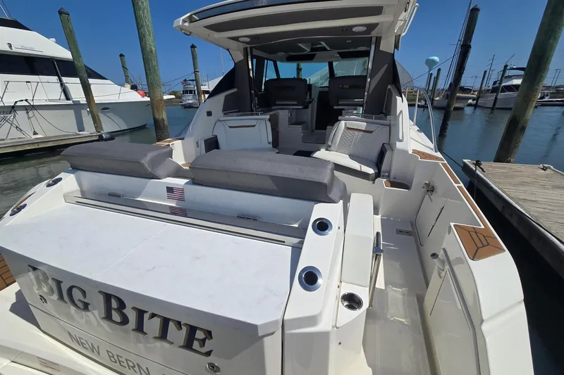 Slide: The Image of 2022 Tiara Yachts 43 LE luxury boat docked, featuring spacious seating and sleek design. - 16