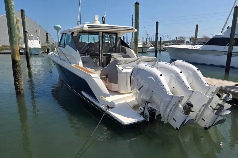 Slide: The Image of 2022 Tiara Yachts 43 LE docked, featuring triple outboard engines. - 2