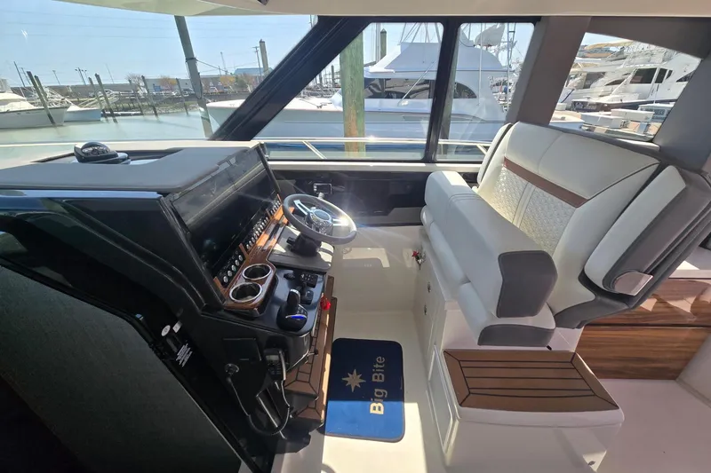 Slide: The Image of 2022 Tiara Yachts 43 LE helm with modern controls and luxurious seating. - 24