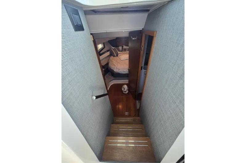 Slide: The Image of Interior view of 2022 Tiara Yachts 43 LE, featuring stairs leading to a cozy cabin. - 27