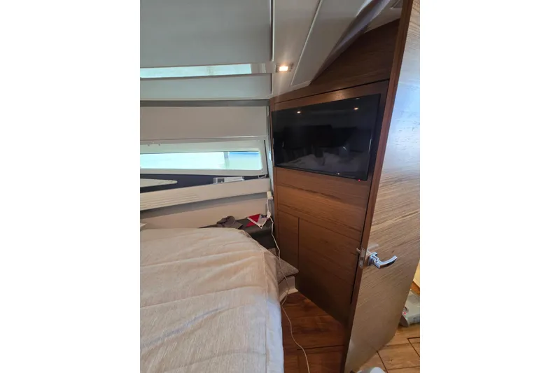 Slide: The Image of Interior of 2022 Tiara Yachts 43 LE, featuring a cozy cabin with a mounted TV. - 30
