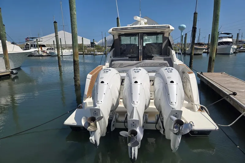 Slide: The Image of 2022 Tiara Yachts 43 LE with triple outboard engines docked at marina. - 4