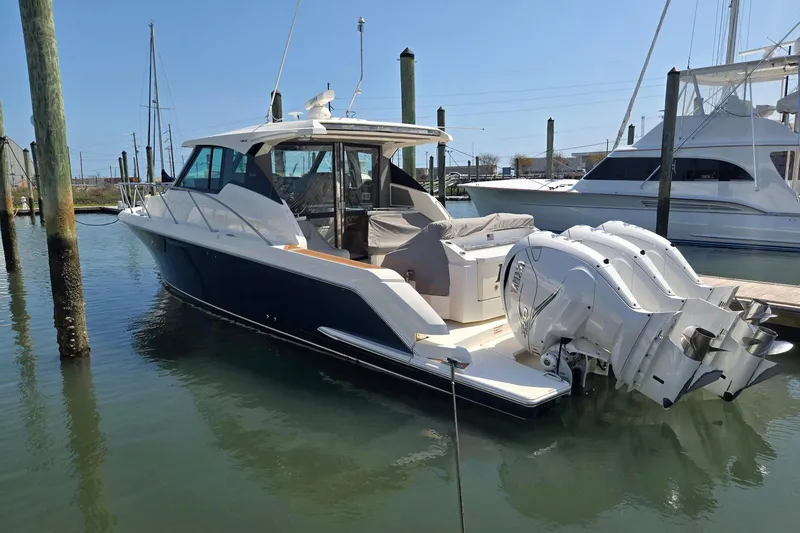 Slide: The Image of 2022 Tiara Yachts 43 LE docked, featuring sleek design and powerful outboard engines. - 6