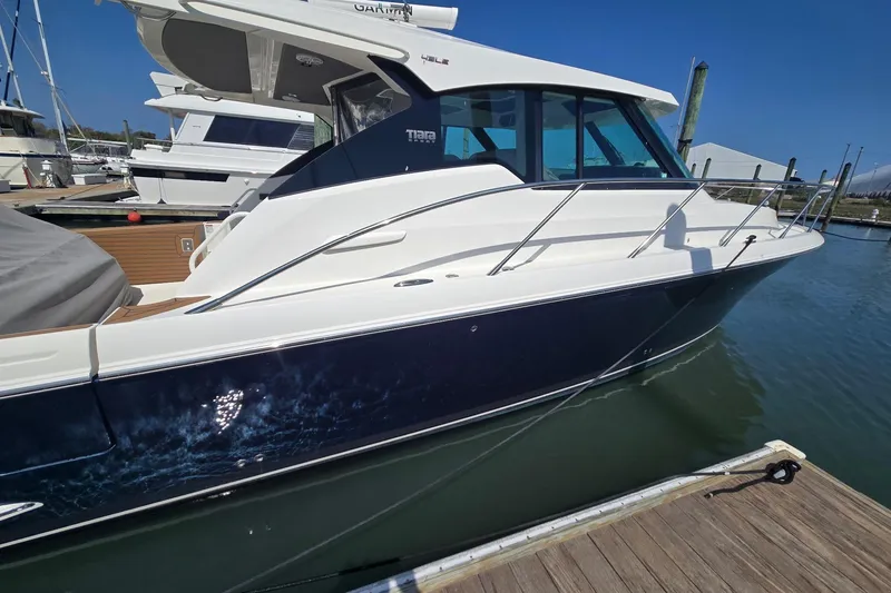 Slide: The Image of 2022 Tiara Yachts 43 LE docked at marina, sleek design, blue and white exterior. - 8