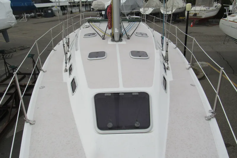 Slide: The Image of 1999 Catalina 380 sailboat deck view, showcasing hatches and rigging in a marina setting. - 10