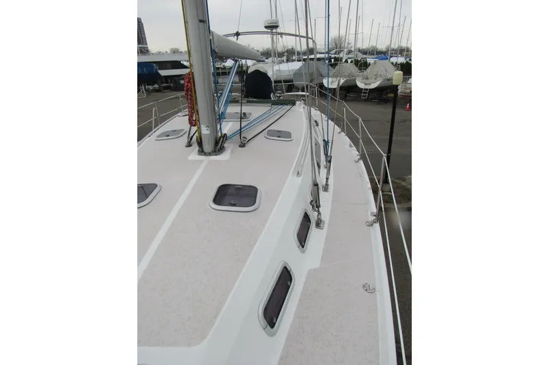Slide: The Image of Deck view of a 1999 Catalina 380 sailboat in a marina setting. - 12