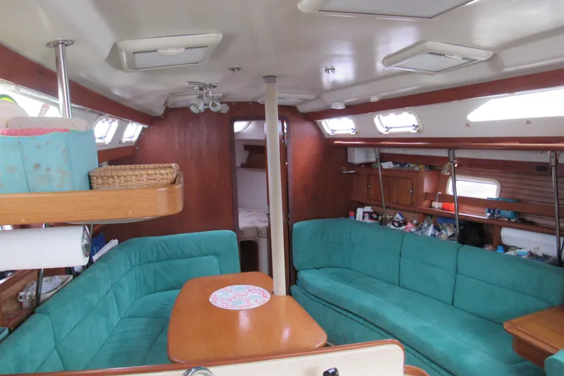 Slide: The Image of Interior of a 1999 Catalina 380 sailboat with teal seating and wooden accents. - 22
