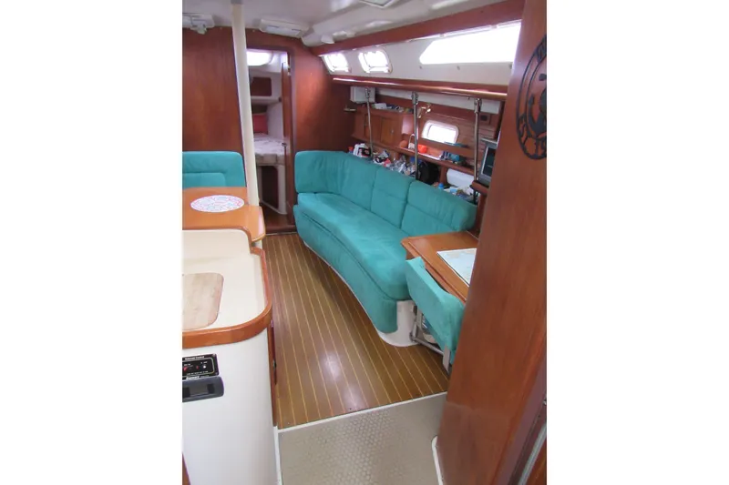 Slide: The Image of Interior of a 1999 Catalina 380 sailboat with teal seating and wooden finishes. - 24