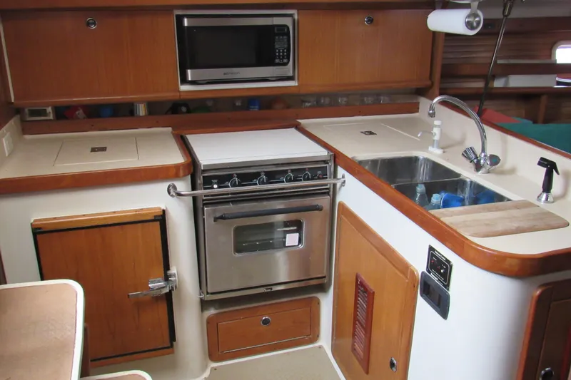 Slide: The Image of Interior of a 1999 Catalina 380 yacht kitchen with stove, sink, and microwave. - 25