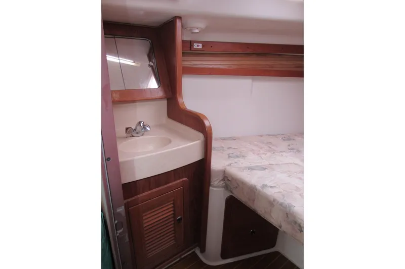 Slide: The Image of Interior of 1999 Catalina 380 sailboat featuring a compact sink and cozy sleeping area. - 27