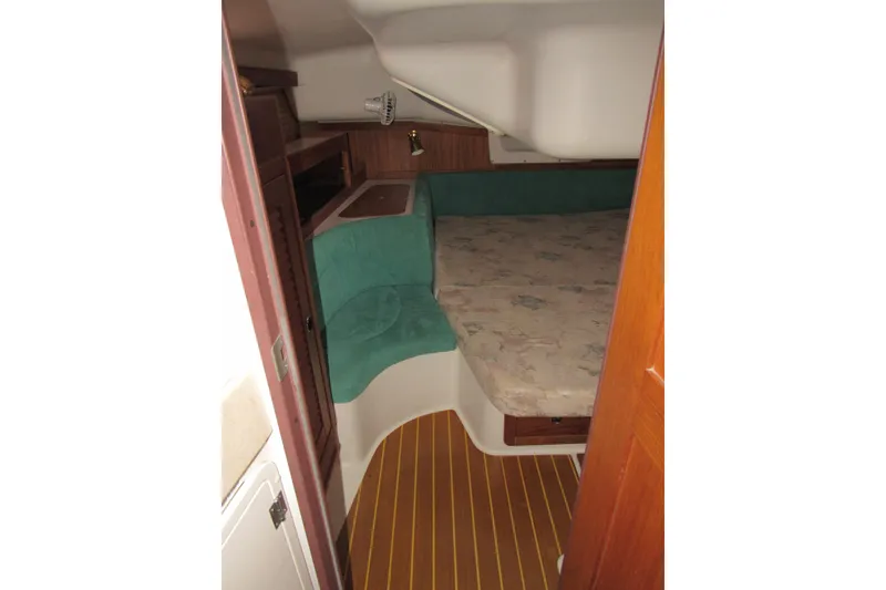 Slide: The Image of Interior cabin of a 1999 Catalina 380 sailboat with a cozy bed and wooden accents. - 33