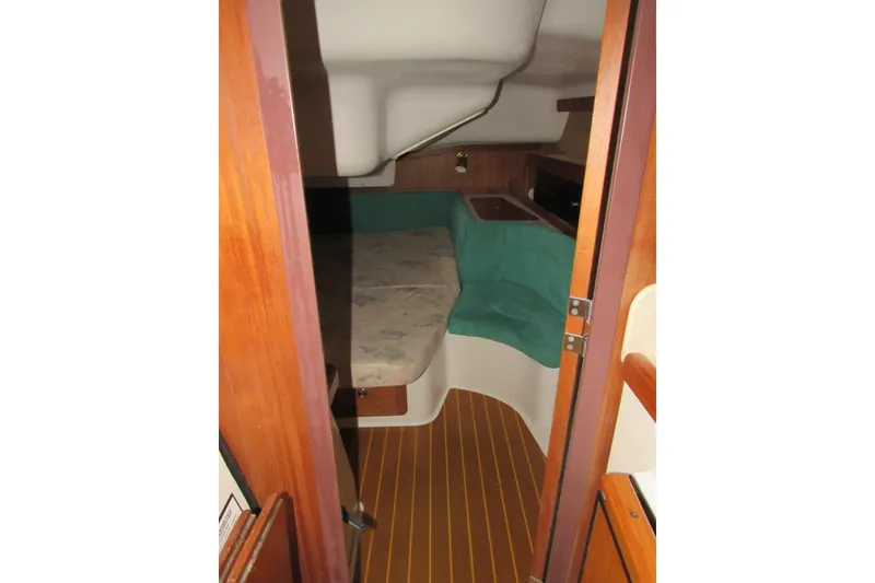 Slide: The Image of 1999 Catalina 380 yacht interior cabin with wooden flooring and cozy seating area. - 35