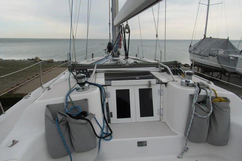 Slide: The Image of 1999 Catalina 380 sailboat deck with ropes and winches, overlooking calm sea. - 7