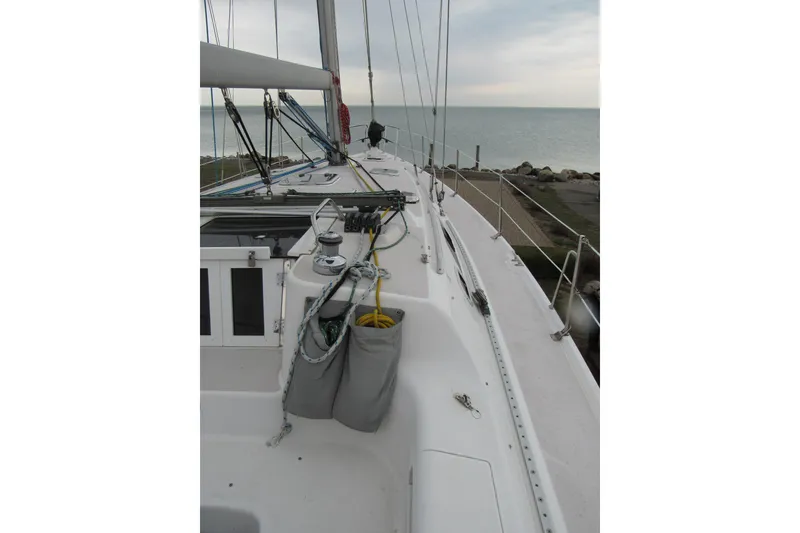 Slide: The Image of 1999 Catalina 380 sailboat deck with ropes and winches, overlooking calm sea. - 9