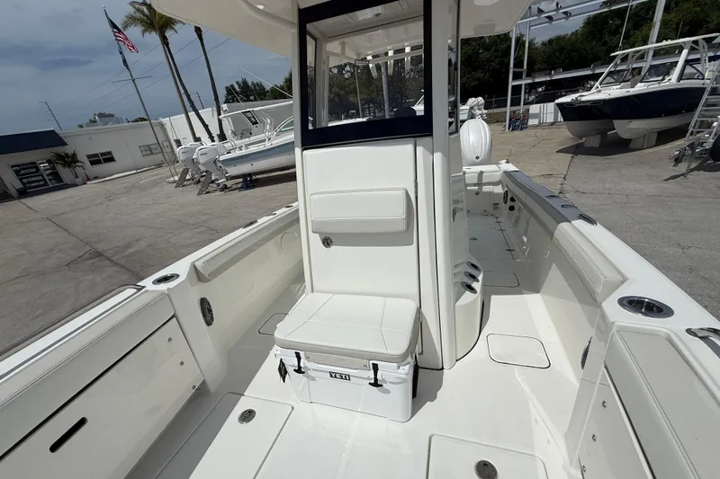Slide: The Image of 2026 World Cat 235 TE boat interior with seating and storage, docked at a marina. - 10