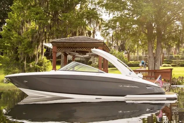 Slide: The Image of Manufacturer Provided Image: 2017 Regal 2800 Bowrider boat docked by a gazebo on a serene lake. - 2