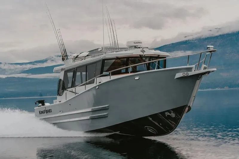 Slide: The Image of 2026 KingFisher 38 GFX boat cruising on a serene lake with mountainous backdrop. - 3
