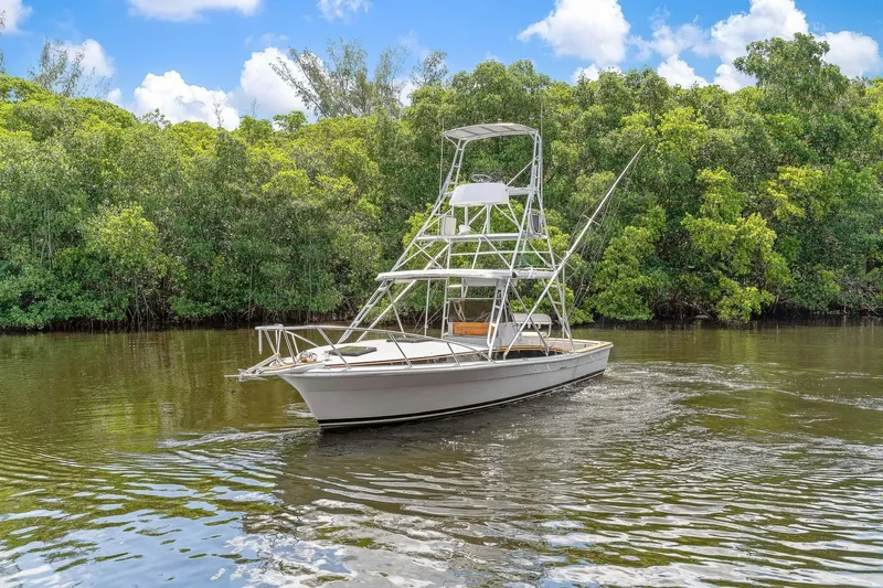 Slide: The Image of 2024 Strike 29' Center Console boat with cuddy, navigating a lush, green waterway. - 48
