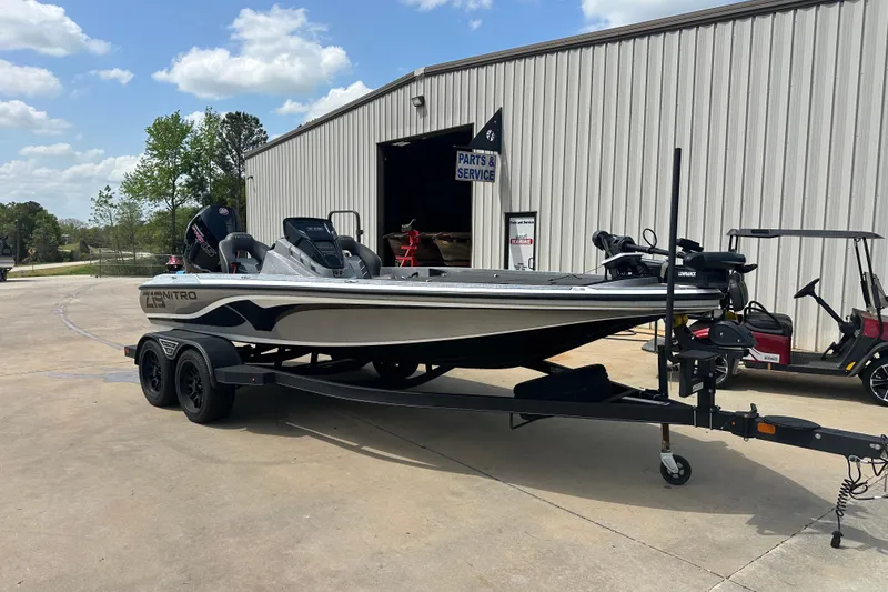 The Image of 2023 Nitro Z19 boat on trailer outside service center under blue sky. - 0