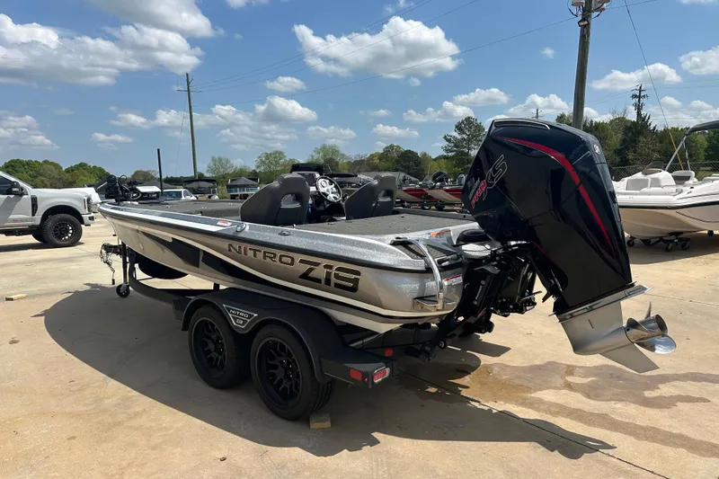 Slide: The Image of 2023 Nitro Z19 boat with powerful outboard motor, parked outdoors under a clear sky. - 2