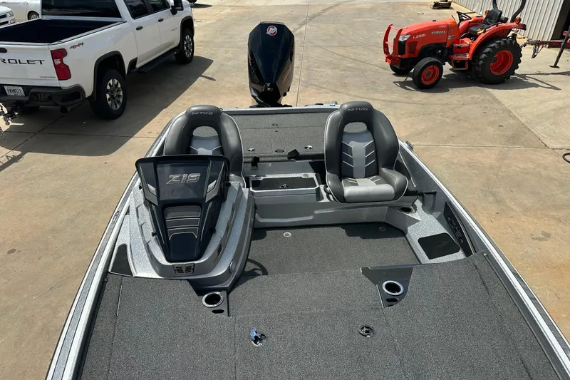 Slide: The Image of 2023 Nitro Z19 boat with dual seats, parked near a truck and tractor. - 9
